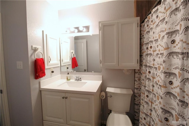 full bathroom featuring vanity, curtained shower, and toilet