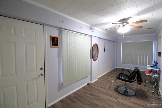 exercise room with a ceiling fan, crown molding, wood finished floors, and baseboards