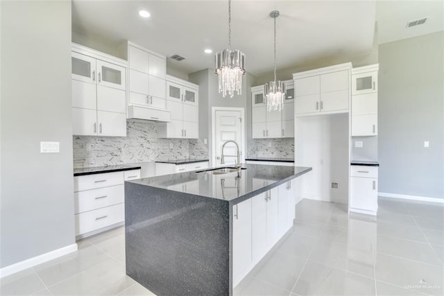 kitchen featuring backsplash, a large island, white cabinetry, and sink