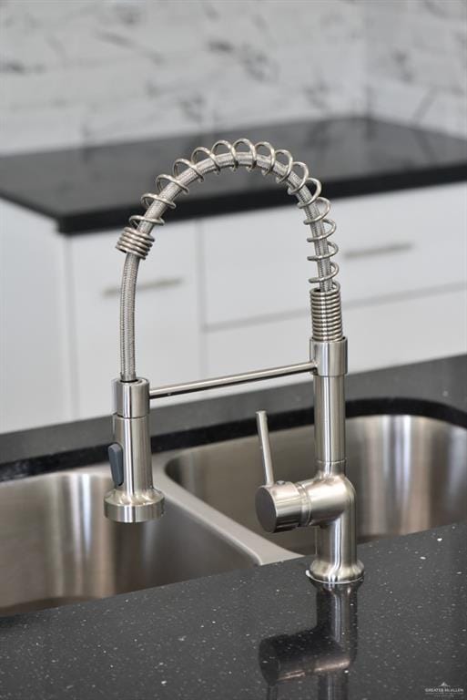 interior details with white cabinetry and sink