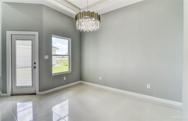 tiled empty room featuring a notable chandelier