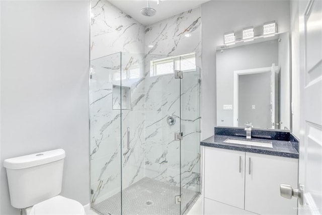 bathroom with vanity, toilet, and a shower with door