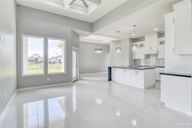 kitchen featuring white cabinetry, beamed ceiling, light tile patterned flooring, and coffered ceiling