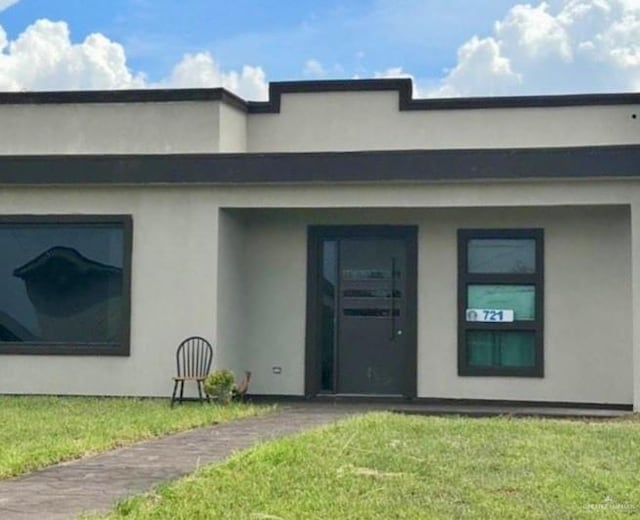 exterior space featuring a lawn and stucco siding