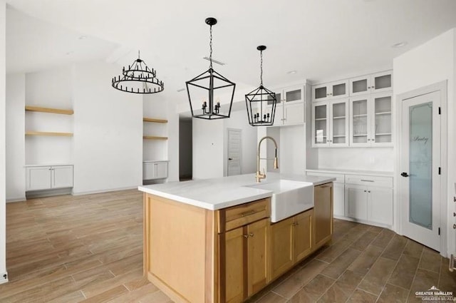 2080 Eagle Landing Dr, Edinburg, TX 78542 - kitchen with a chandelier, light wood-style floors, glass insert cabinets, and light countertops