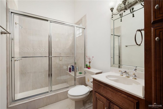 bathroom featuring vanity, toilet, and a shower stall