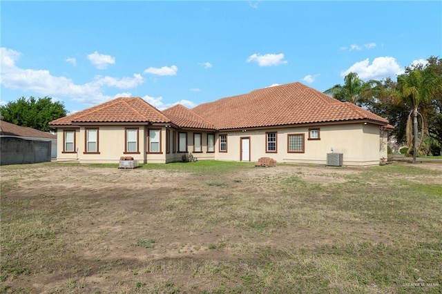 back of house with a tile roof, central air condition unit, and stucco siding