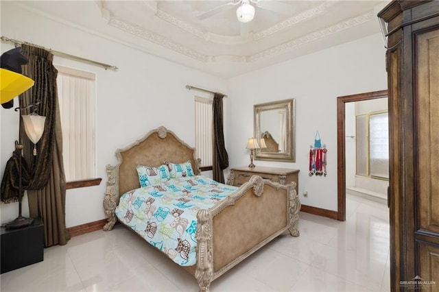 bedroom with a ceiling fan, light tile patterned flooring, a tray ceiling, and baseboards