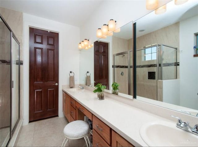 bathroom featuring tile patterned flooring, vanity, and a shower with shower door