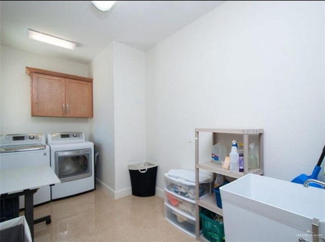 laundry area with cabinets, washing machine and dryer, and sink