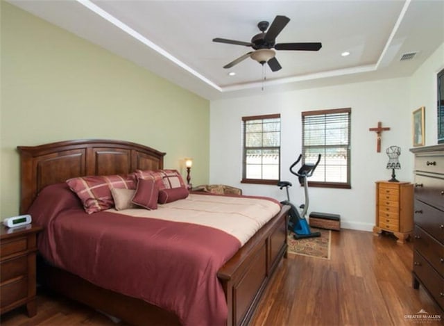 bedroom featuring a tray ceiling, ceiling fan, and dark hardwood / wood-style floors