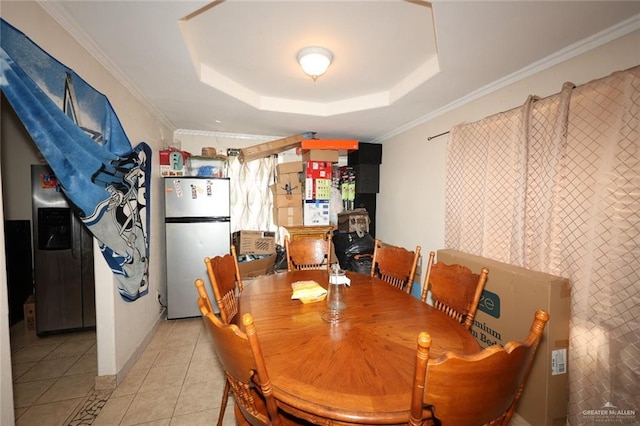 tiled dining area with tile walls, crown molding, and a tray ceiling