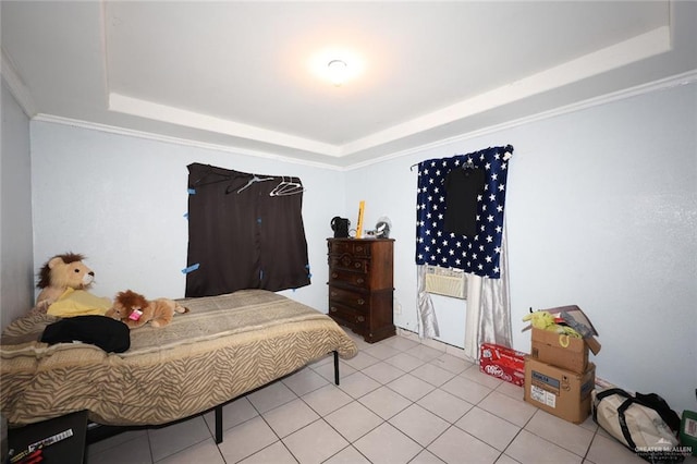 bedroom with ornamental molding, light tile patterned floors, and a tray ceiling