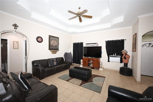 tiled living room featuring a tray ceiling, ceiling fan, and crown molding