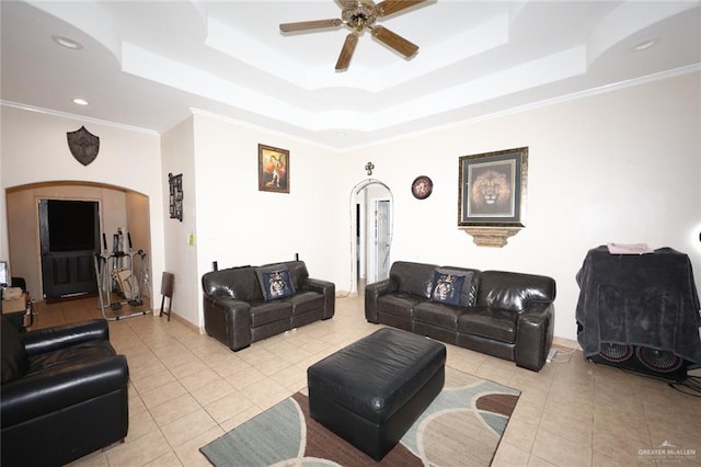 tiled living room with a tray ceiling, ceiling fan, and ornamental molding