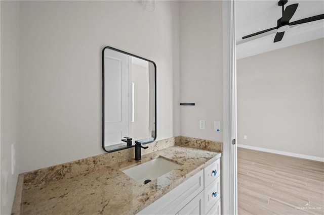 bathroom with hardwood / wood-style flooring, vanity, and ceiling fan