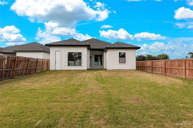 rear view of property with a lawn