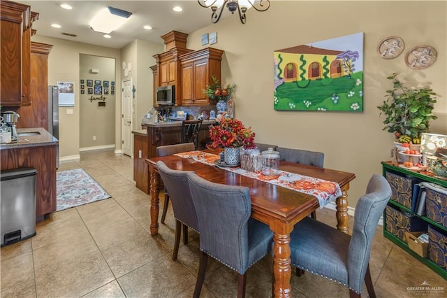 tiled dining area featuring sink and a chandelier