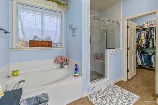 bathroom with shower with separate bathtub and tile patterned floors