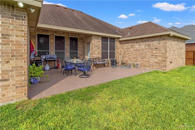 rear view of house featuring a yard and a patio