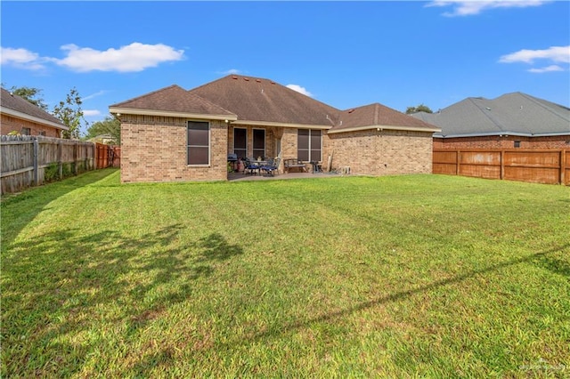 back of house featuring a lawn and a patio