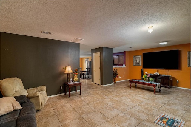 living room featuring light tile patterned floors and a textured ceiling