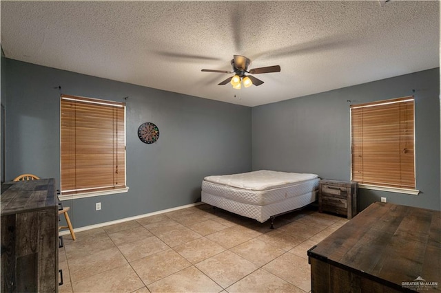 tiled bedroom with ceiling fan and a textured ceiling