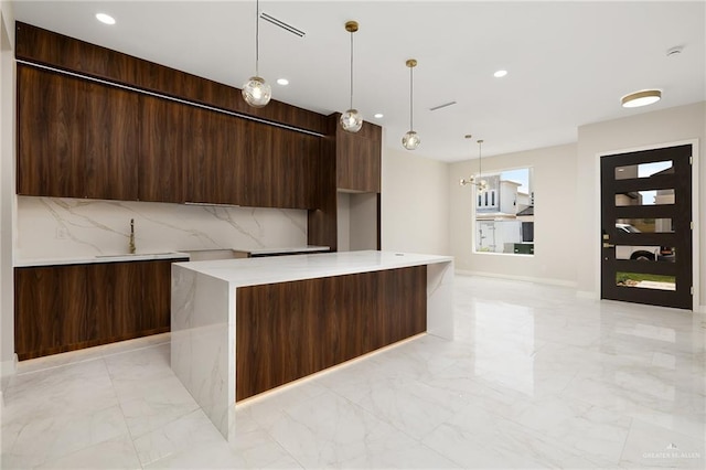 kitchen with recessed lighting, modern cabinets, marble finish floor, and a center island