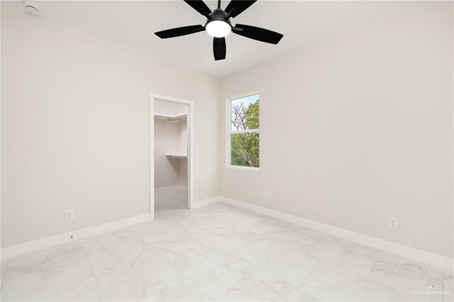 2705 E Solar Dr, Mission, TX 78501 - unfurnished bedroom featuring baseboards, marble finish floor, a walk in closet, and ceiling fan