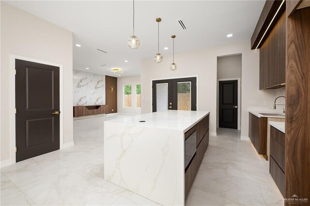 2705 E Solar Dr, Mission, TX 78501 - kitchen featuring a sink, french doors, marble finish floor, a large island, and modern cabinets