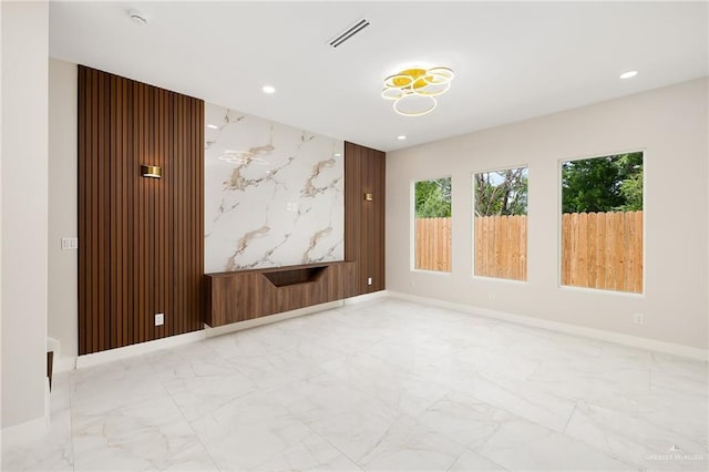unfurnished room featuring baseboards, visible vents, recessed lighting, and marble finish floor