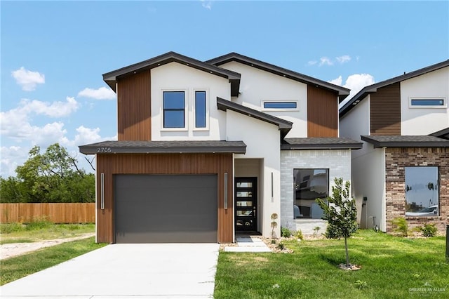 contemporary house featuring fence, a front yard, a shingled roof, concrete driveway, and an attached garage