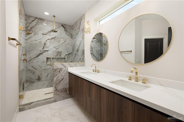 bathroom with a sink, a marble finish shower, double vanity, and marble finish floor