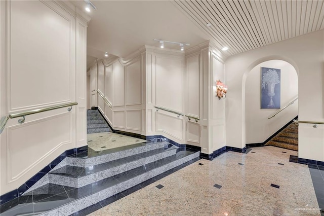 334 Padre Blvd Unit 801, South Padre Island, TX 78597 - stairway with granite tiled floors, inlaid floor details, a decorative wall, arched walkways, and baseboards