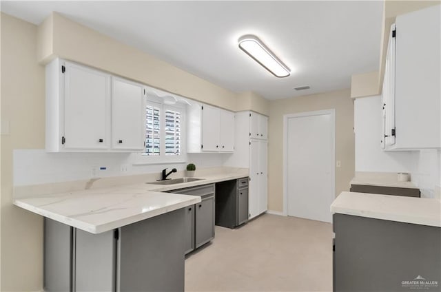 413 W Jonquil Ave, Mcallen, TX 78501 - kitchen featuring a sink, a peninsula, white cabinetry, and light stone countertops
