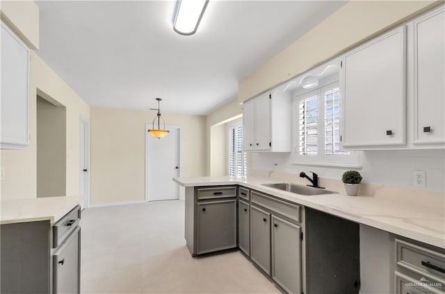 413 W Jonquil Ave, Mcallen, TX 78501 - kitchen with a sink, gray cabinetry, a peninsula, light floors, and hanging light fixtures