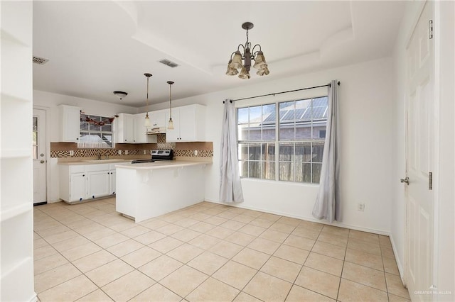 kitchen with stainless steel electric range, white cabinets, a raised ceiling, hanging light fixtures, and kitchen peninsula