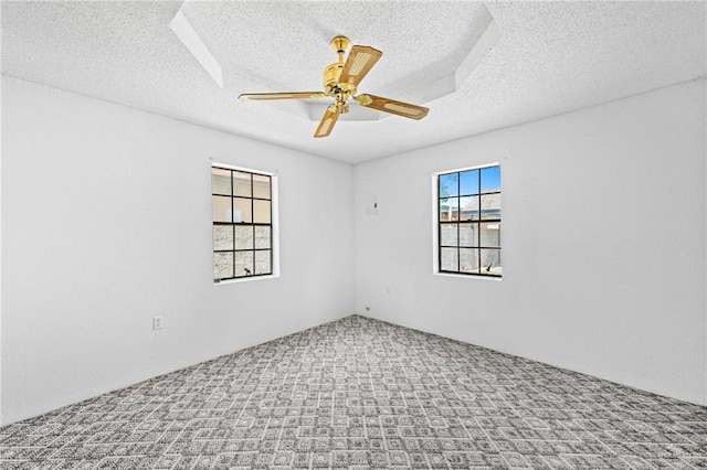 carpeted empty room with ceiling fan and a textured ceiling