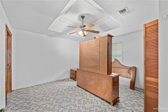 interior space featuring ceiling fan, light colored carpet, and a textured ceiling