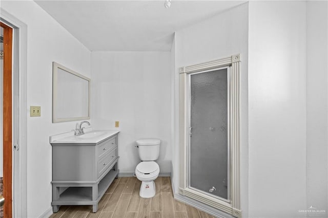 bathroom with vanity, toilet, and walk in shower