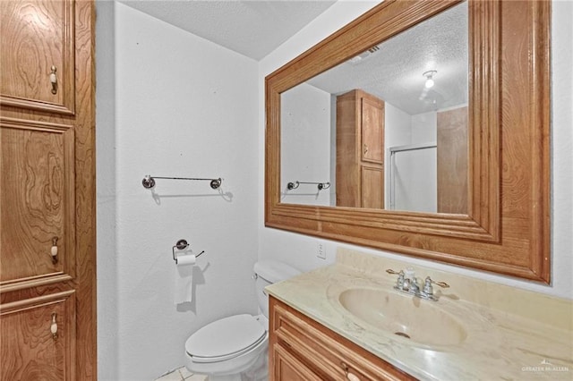 bathroom featuring vanity, a shower, a textured ceiling, and toilet