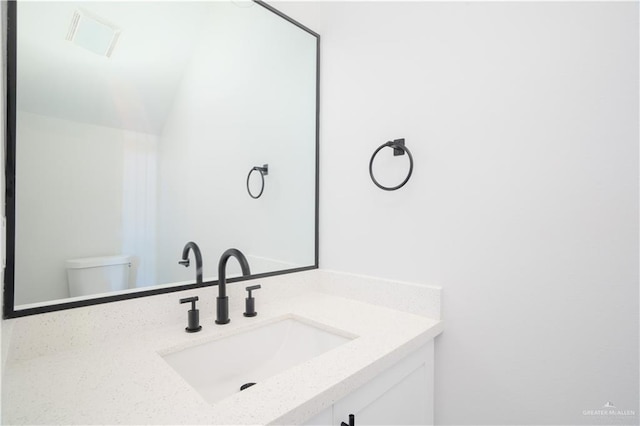 218 Kansas Ave, Weslaco, TX 78596 - bathroom with toilet, vanity, and visible vents