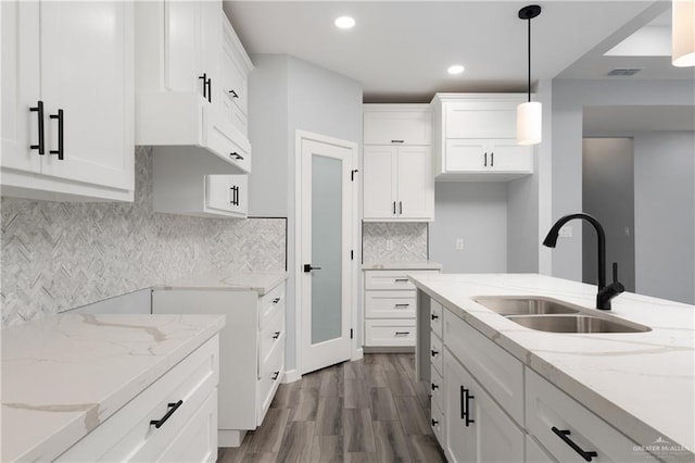 2023 Peace Dr, La Feria, TX 78559 - kitchen featuring a sink, dark wood finished floors, light stone counters, hanging light fixtures, and white cabinets