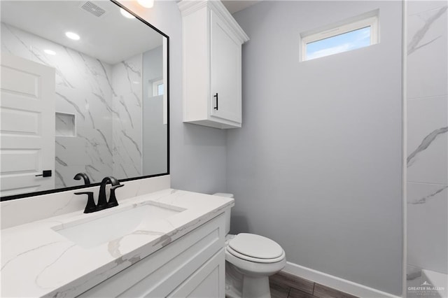 2023 Peace Dr, La Feria, TX 78559 - bathroom featuring vanity, toilet, wood finished floors, and baseboards