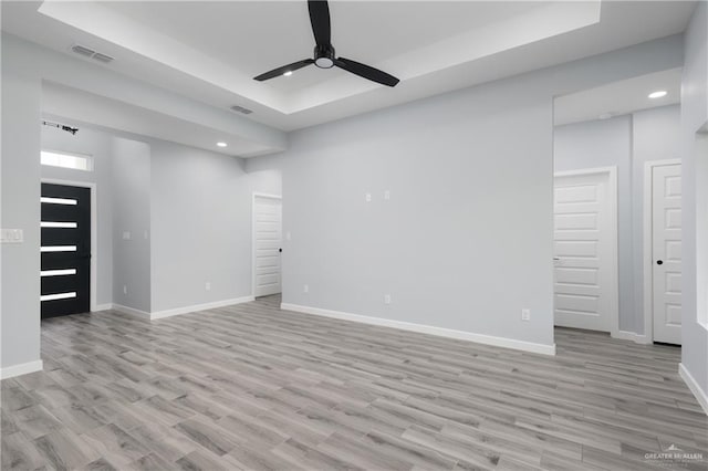 2023 Peace Dr, La Feria, TX 78559 - unfurnished living room with a tray ceiling, recessed lighting, ceiling fan, baseboards, and light wood-style floors