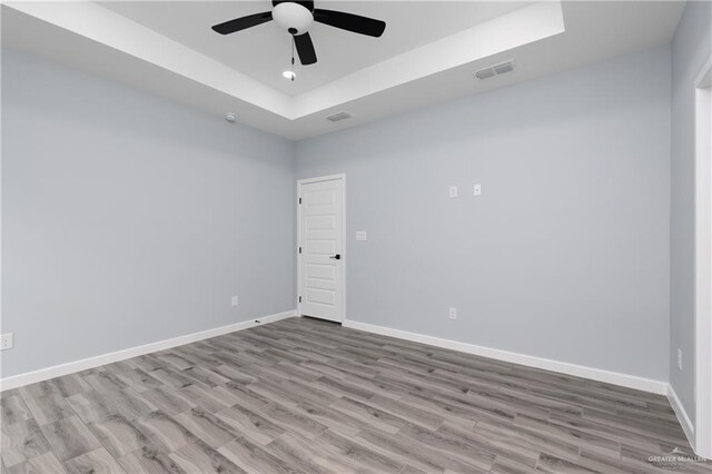 2023 Peace Dr, La Feria, TX 78559 - unfurnished room with a tray ceiling, a ceiling fan, wood finished floors, and baseboards