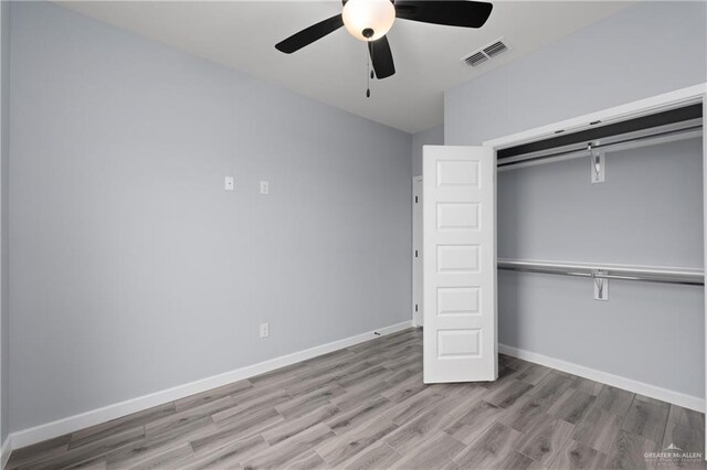 2023 Peace Dr, La Feria, TX 78559 - unfurnished bedroom with wood finished floors, a closet, baseboards, and a ceiling fan