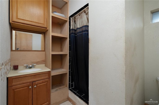 bathroom with a shower with shower curtain, built in shelves, and vanity