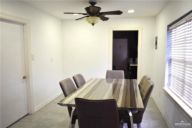 dining room with a ceiling fan, baseboards, and light tile patterned floors