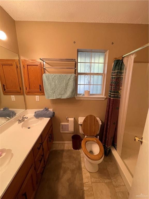 bathroom with toilet, vanity, a textured ceiling, and walk in shower